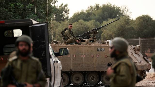 Israeli soldier sits on APC near Israel's border with Lebanon