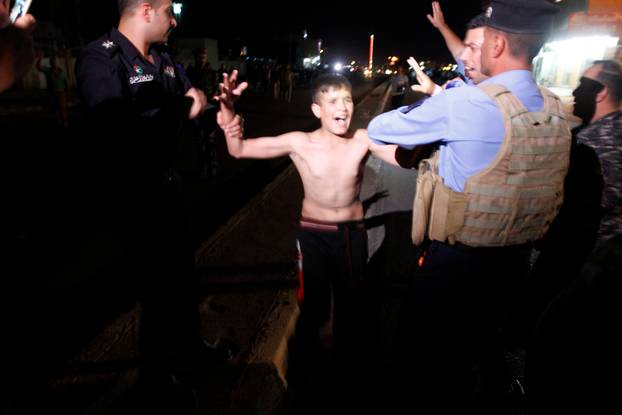 Iraqi security forces detain a boy after removing a suicide vest from him in Kirkuk