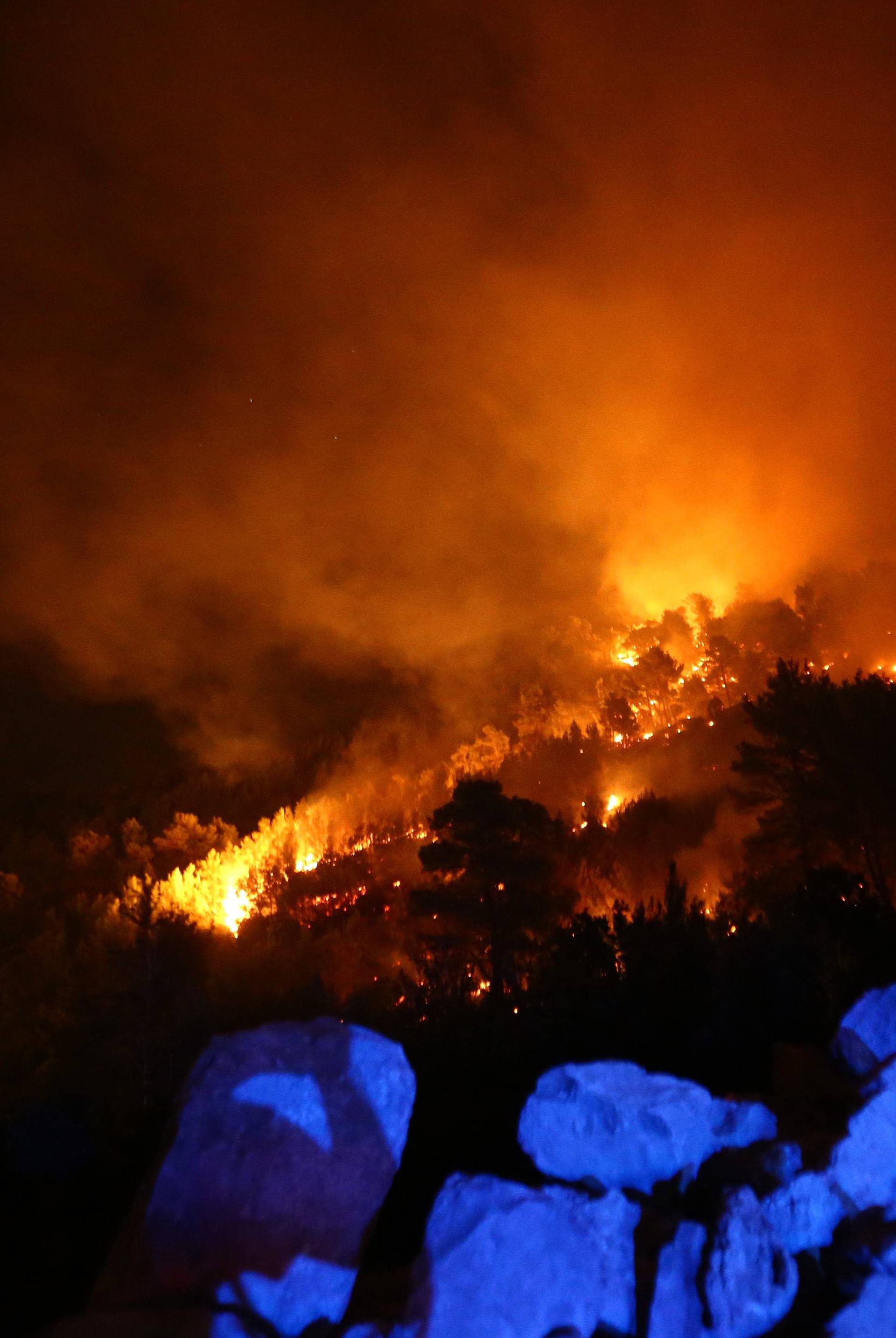 A man observes wildfire in the village of Mravince near Split