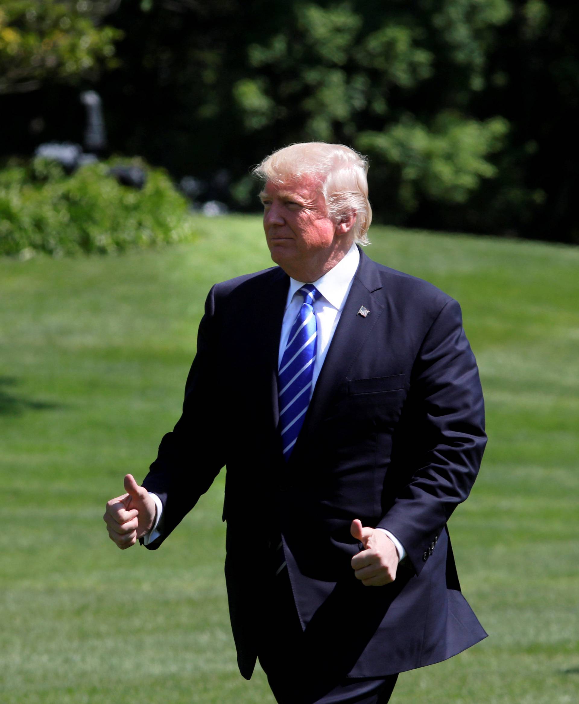 President Donald Trump gestures as he walks on the South Lawn