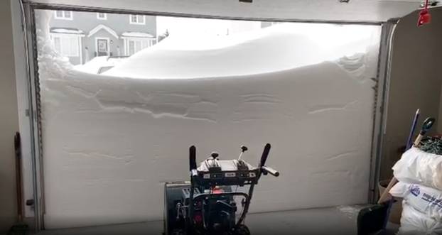 Pile of snow outside a garage is pictured in St John