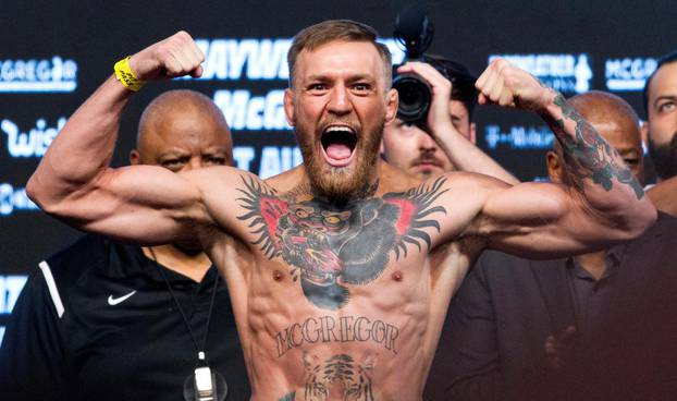 FILE PHOTO: UFC lightweight champion Conor McGregor of Ireland poses on the scale during his official weigh-in at T-Mobile Arena in Las Vegas