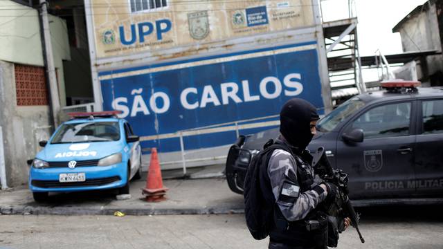 A policeman patrols past a Peacekeeping Police Unit (UPP) during an operation against drug dealers in Sao Carlos slums complex in Rio de Janeiro