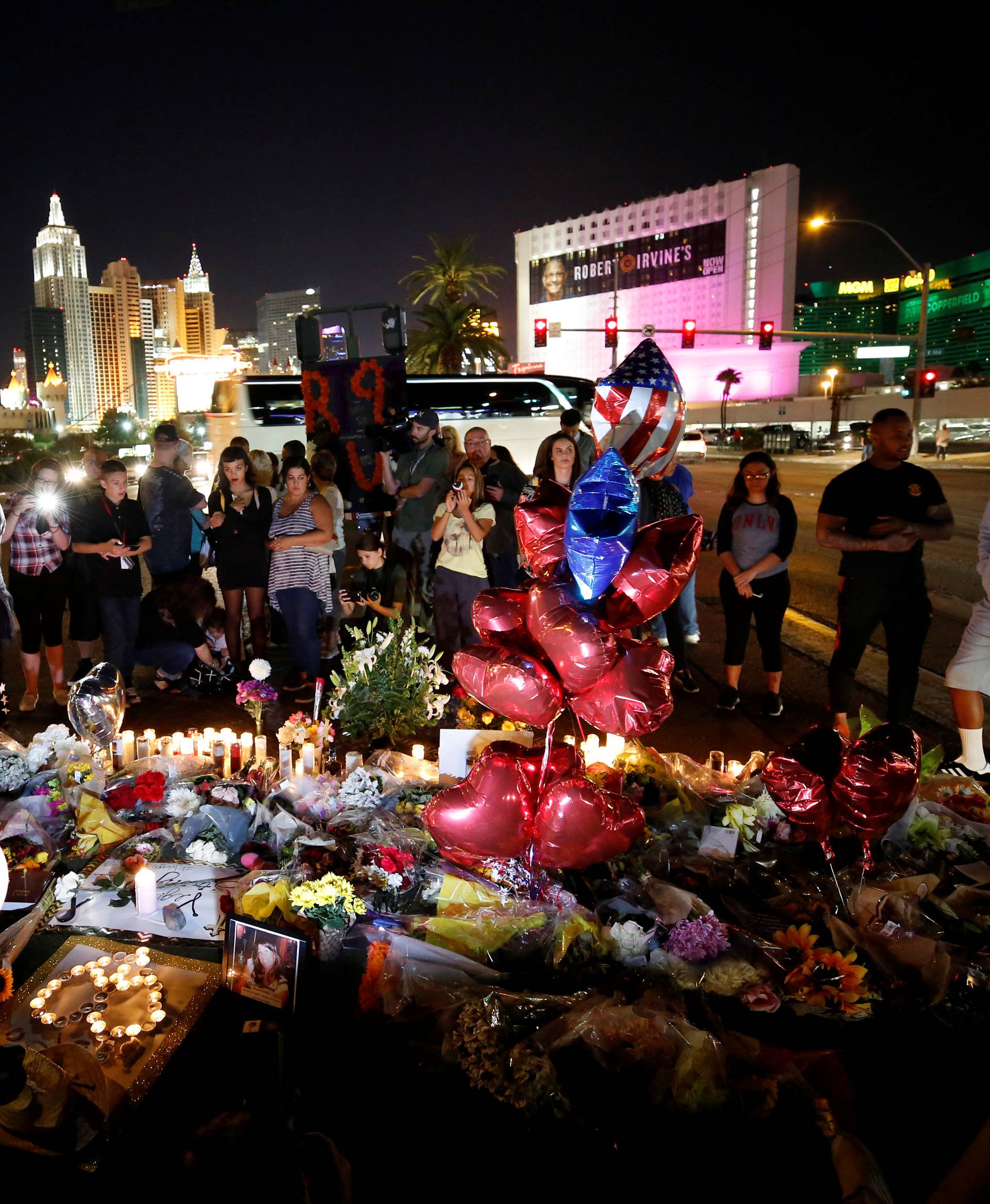 People gather at a makeshift memorial in the middle of Las Vegas Boulevard following the mass shooting in Las Vegas