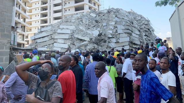People gather at the site of a collapsed 21-story building in Ikoyi, Lagos