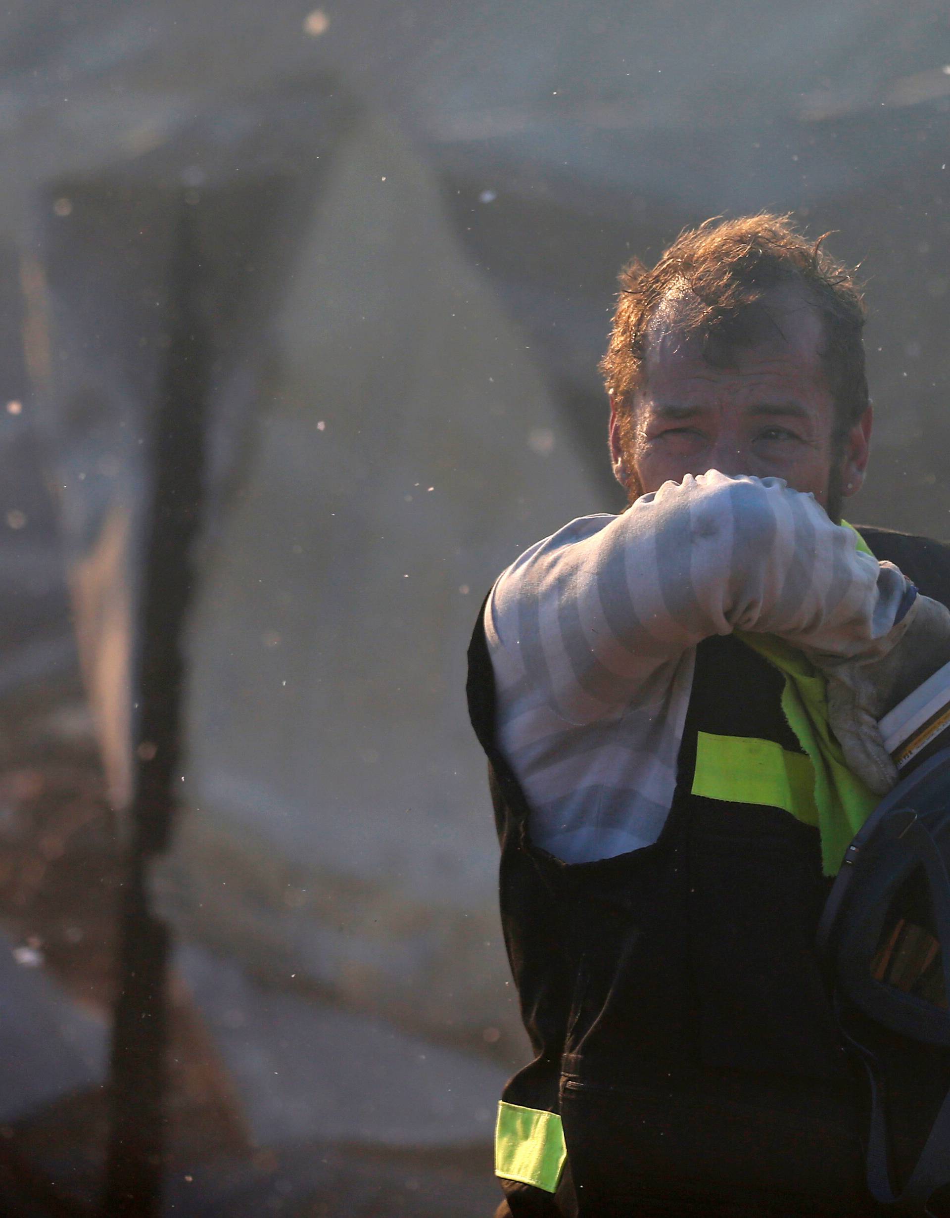 A Firefighter reacts after to work to extinguish a fire following the spread of wildfires in Valparaiso