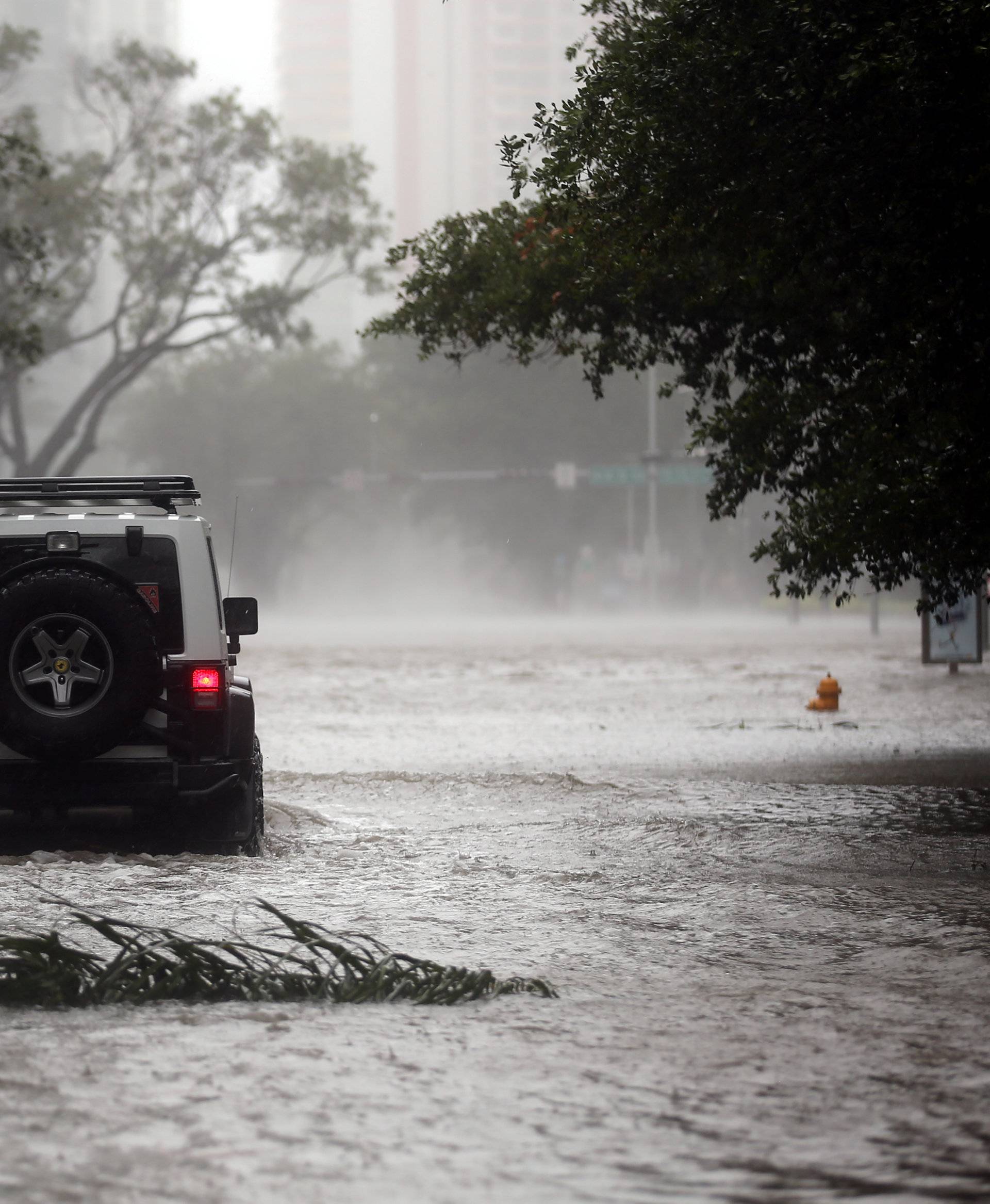 A vehicle drives along a flooded street in downtown Miami as Hurricane Irma arrives at south Florida