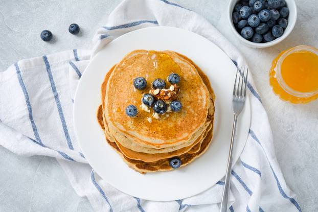 Stack,Of,Pancakes,With,Blueberries,,Walnuts,And,Honey,Served,On