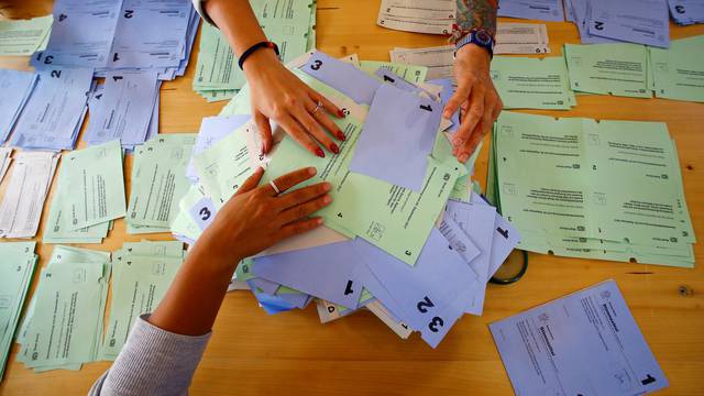 Members of an election office sort ballots in Zurich