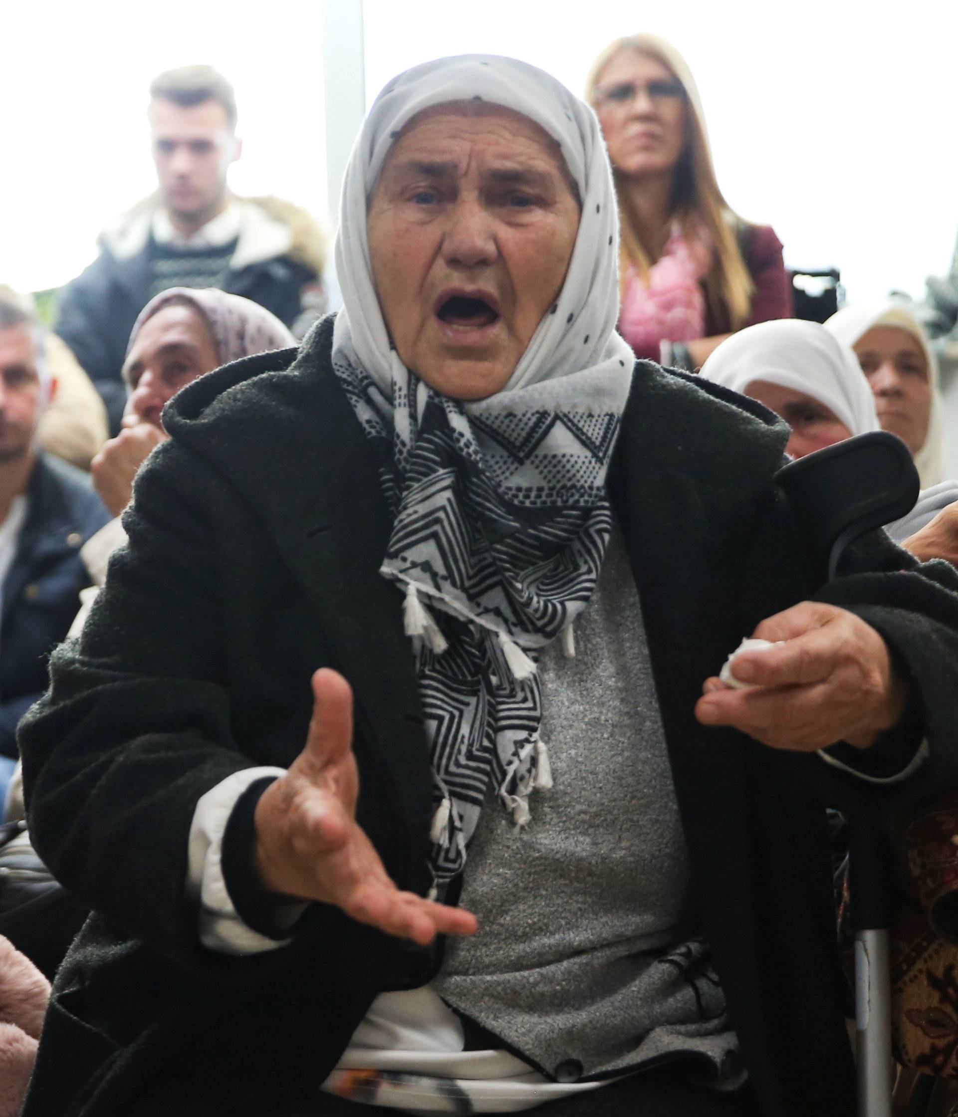 A woman reacts as she watches a television broadcast of the court proceedings of former Bosnian Serb general Ratko Mladic in the Memorial centre Potocari near Srebrenica