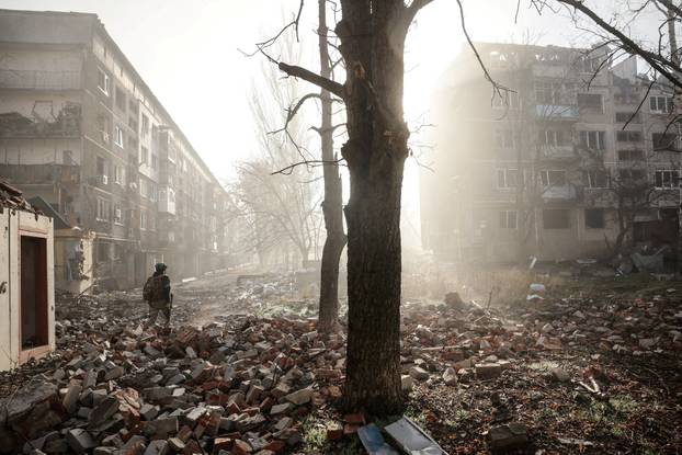 FILE PHOTO: Ukrainian serviceman walks near apartment buildings damaged by a Russian military strike in the frontline town of Kostiantynivka
