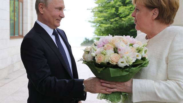 Russian President Putin welcomes German Chancellor Merkel during their meeting in Sochi