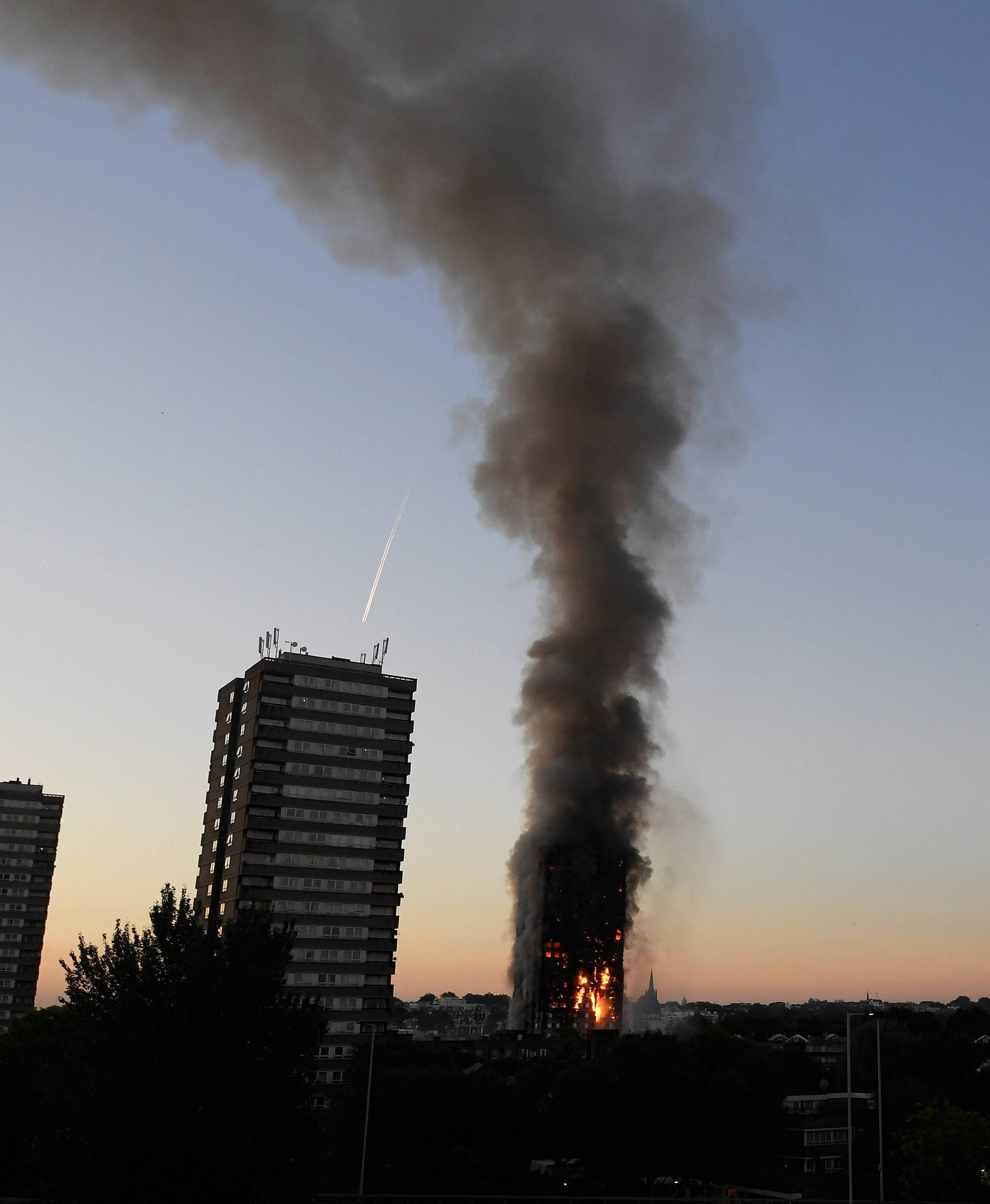 Flames and smoke billow as firefighters deal with a serious fire in a tower block at Latimer Road in West London