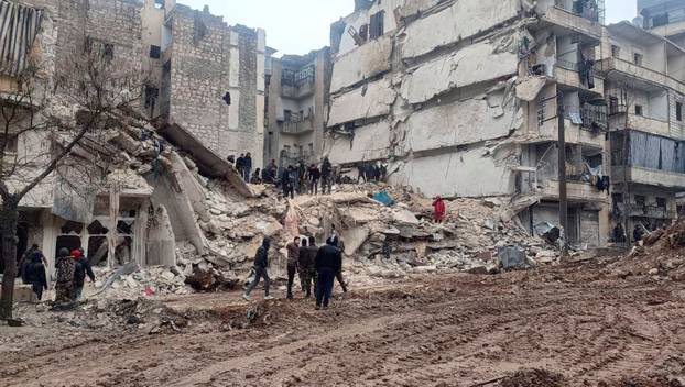 Rescuers search for survivors at the site of a collapsed building, following an earthquake in Aleppo