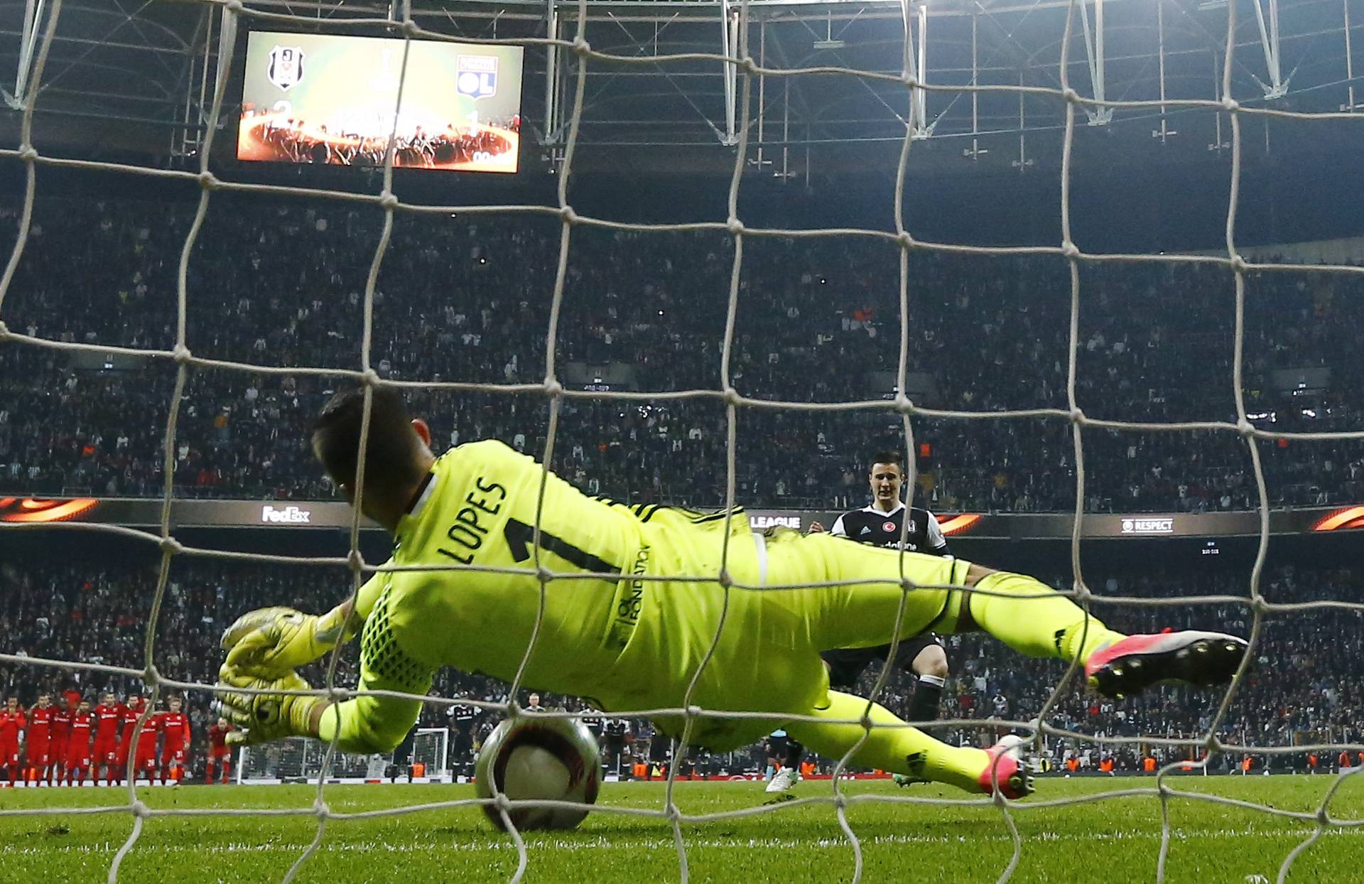 Lyon's Anthony Lopes saves a penalty from Besiktas' Matej Mitrovic