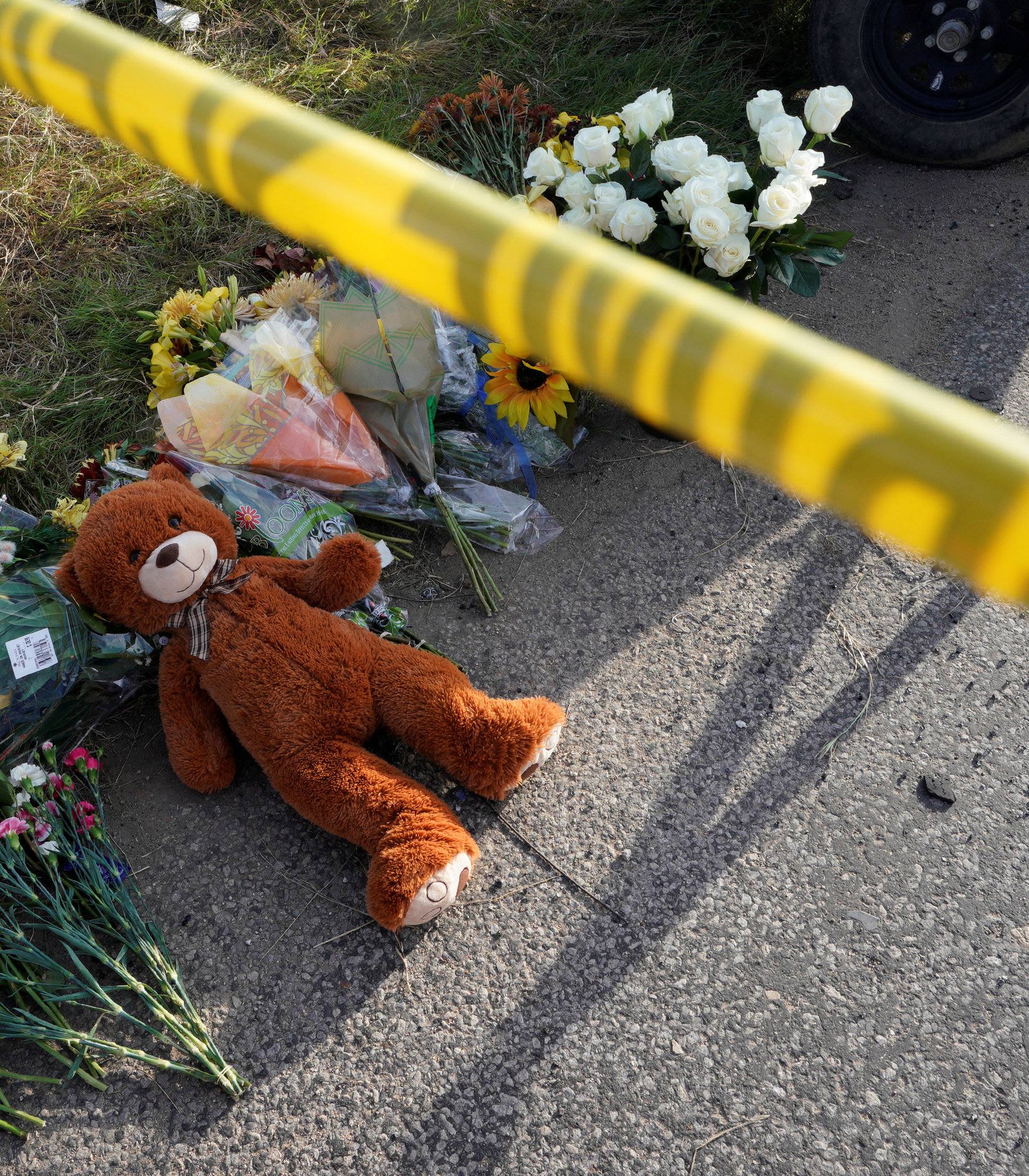 A Teddy bear lies under police tape at a makeshift memorial for those killed in the shooting at the First Baptist Church of Sutherland
