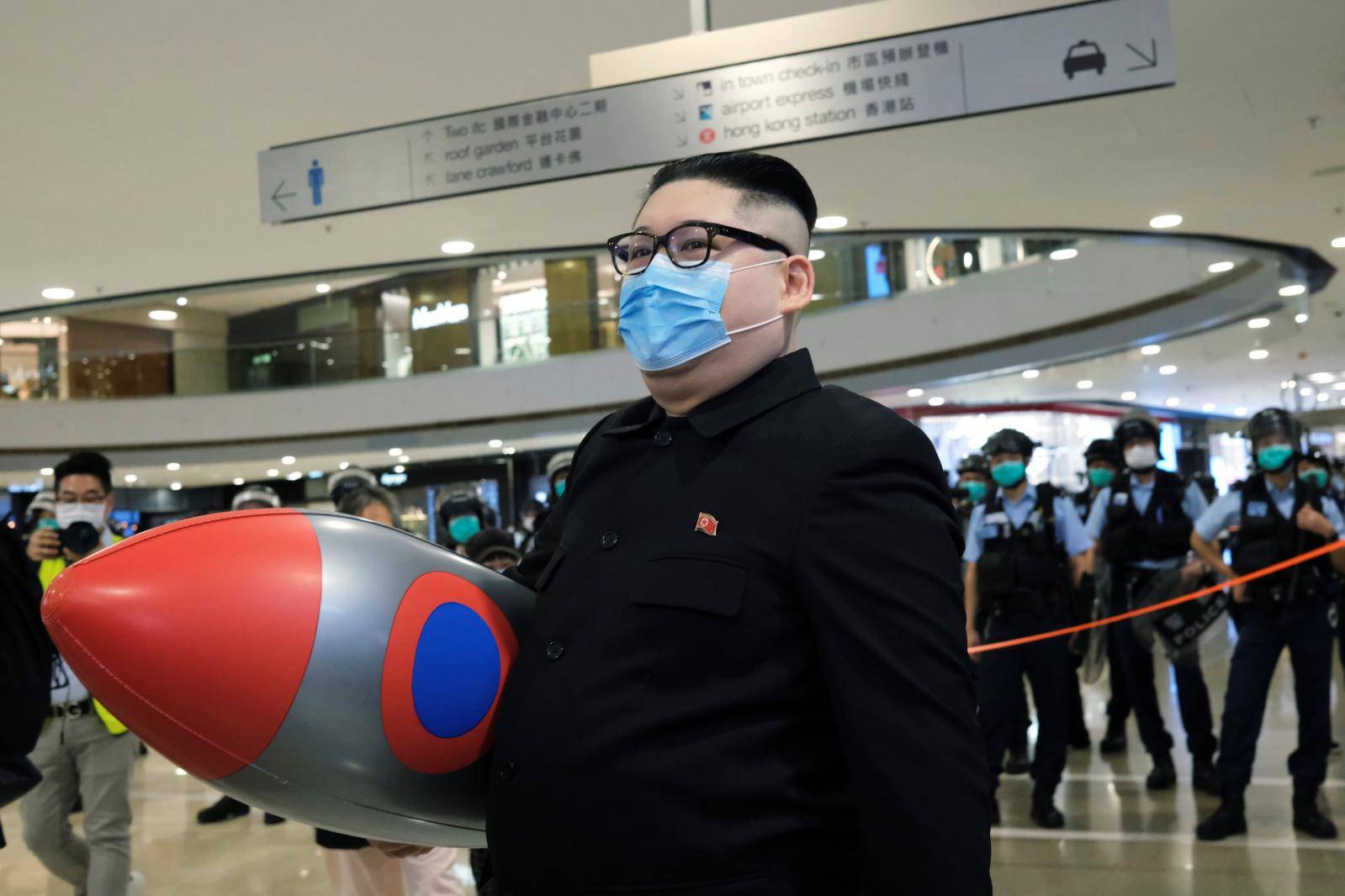 Howard X, an Australian-Chinese impersonating North Korean leader Kim Jong-un walks near riot police as officers clear the crowd in a mall to avoid the spread of the coronavirus disease (COVID-19) during an anti-government protest in Hong Kong