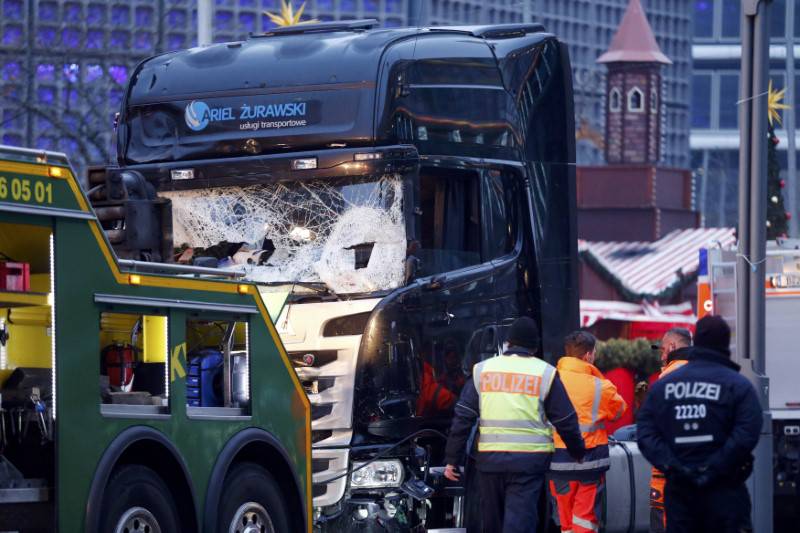 Rescue workers and police inspect the crashed truck at a Berlin Christmas market