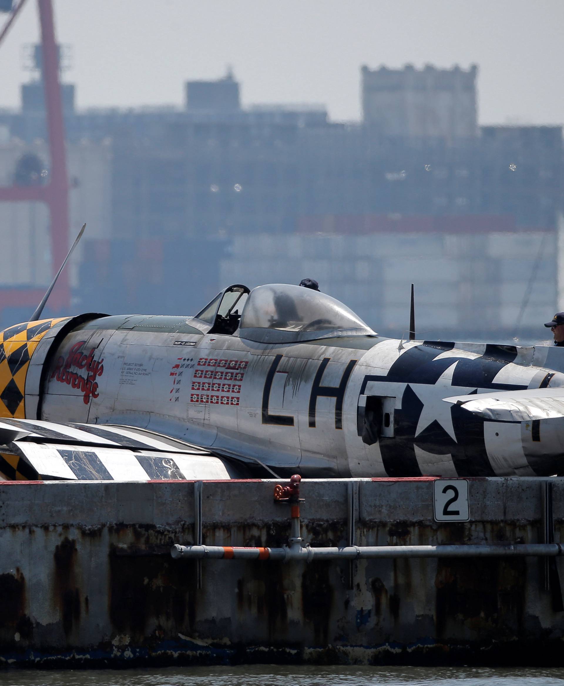 FAA investigators look over the wreckage of a vintage P-47 Thunderbolt airplane that crashed in the Hudson River in New York 