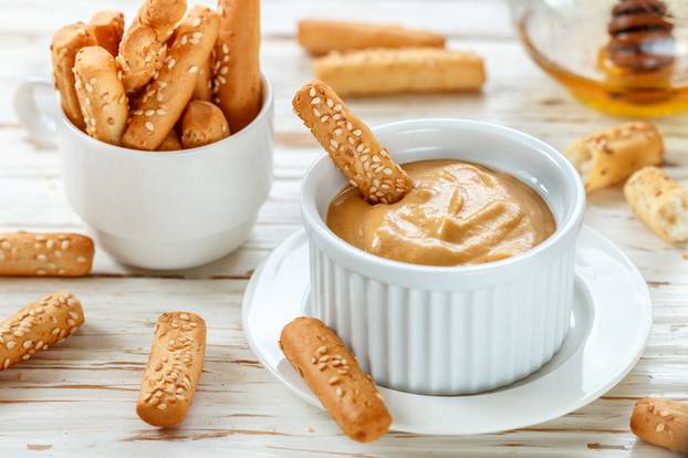 Bread sticks with sesame seeds with mustard and honey dip sauce.