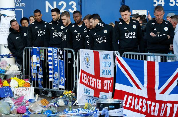 Leicester City players look at tributes left for Leicester City