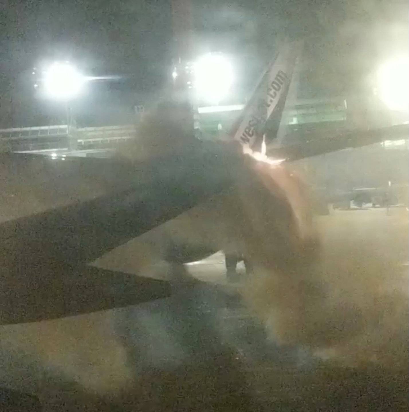 An explosion is seen through a window of a plane that has collided with another plane at Toronto's Pearson Airport, Canada