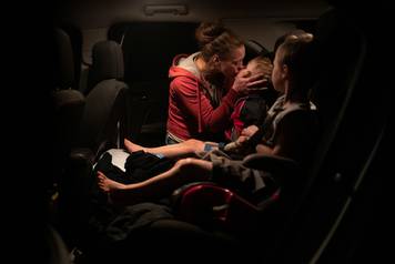 Mom kisses twins as they evacuate from their home ahead of the Obenchain Fire in Butte Falls, Oregon