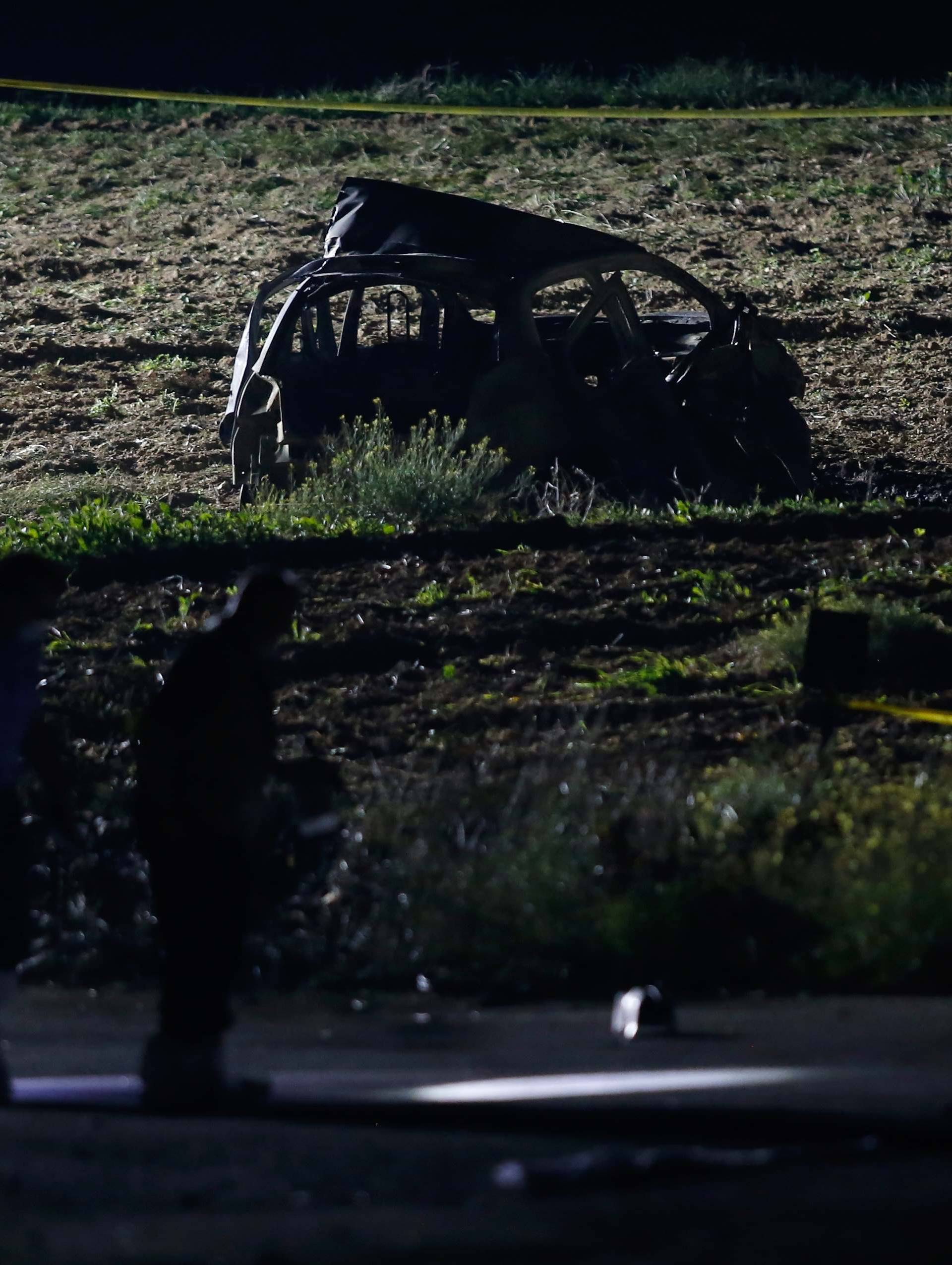 Forensic experts use lights as they look for evidence on a road after a powerful bomb blew up a car killing investigative journalist Daphne Caruana Galizia in Bidnija