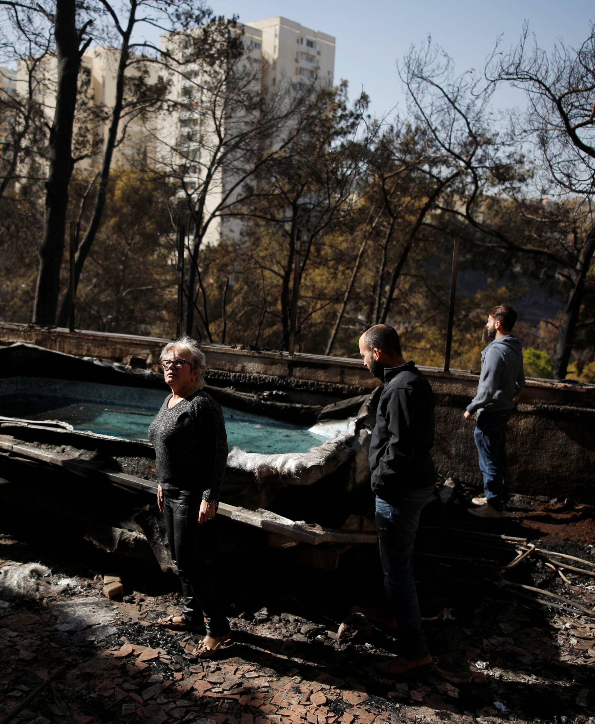 A family examines the damage caused to their house from Thursday's fire in the northern city of Haifa