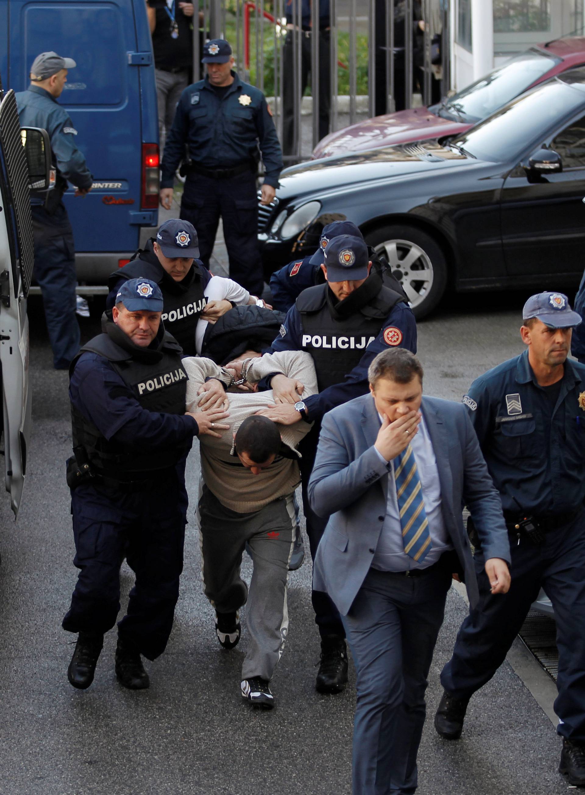 Montenegrin police escort men to a court session with the state attorney in Podgorica