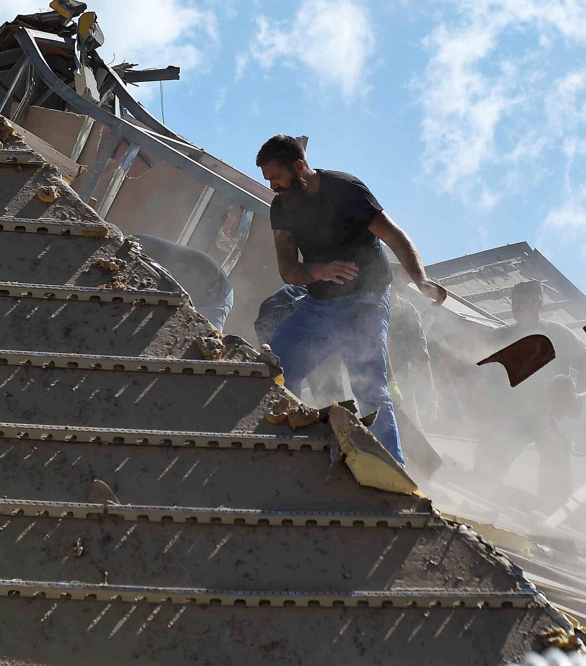 Rescuers work at a collapsed building following an earthquake in Amatrice