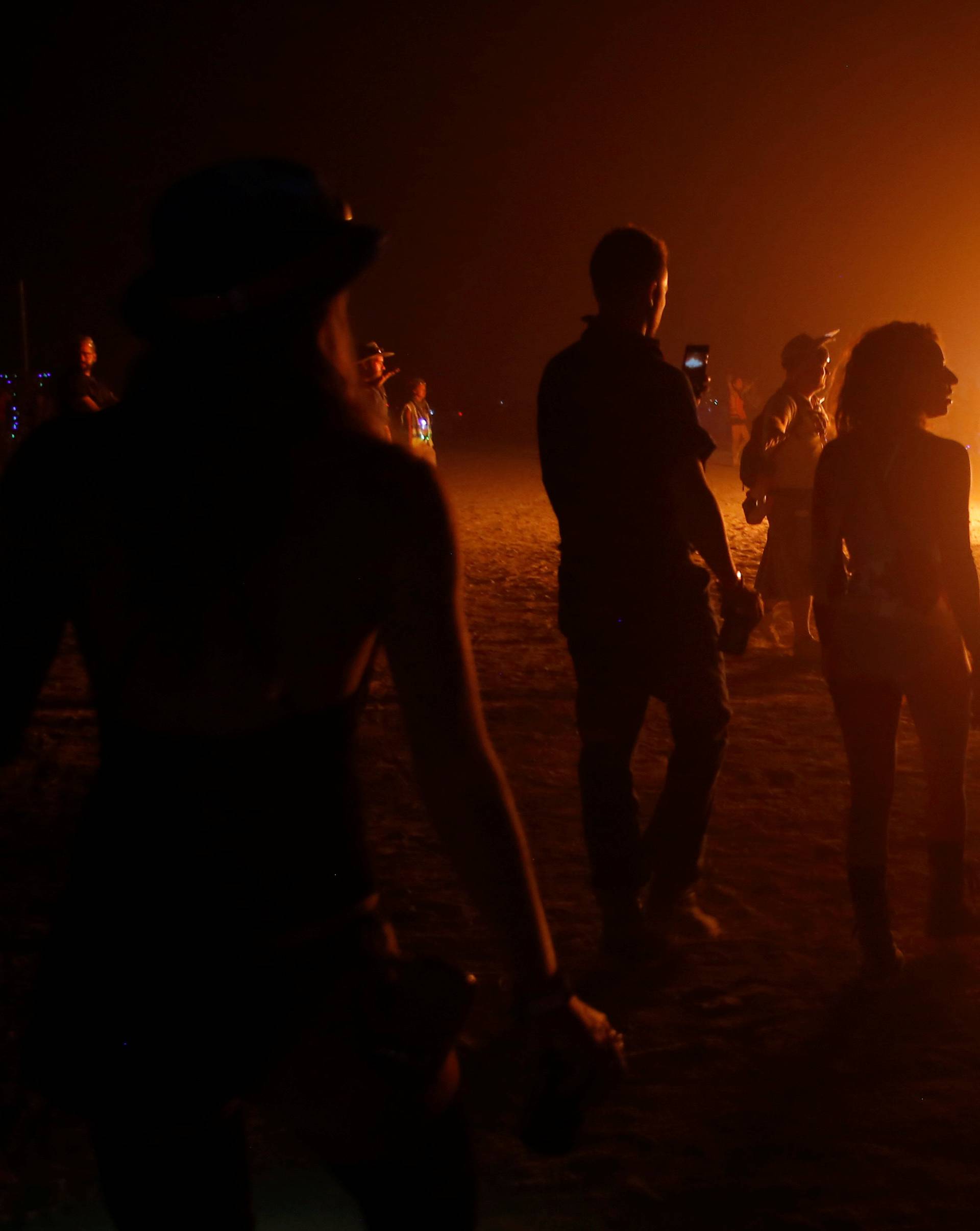 Participants approach a burning art installation as approximately 70,000 people from all over the world gathered for the annual Burning Man arts and music festival in the Black Rock Desert of Nevada