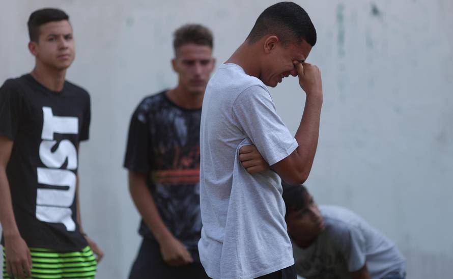 People wait for information in front of the training center of Rio's soccer club Flamengo, after a deadly fire in Rio de Janeiro