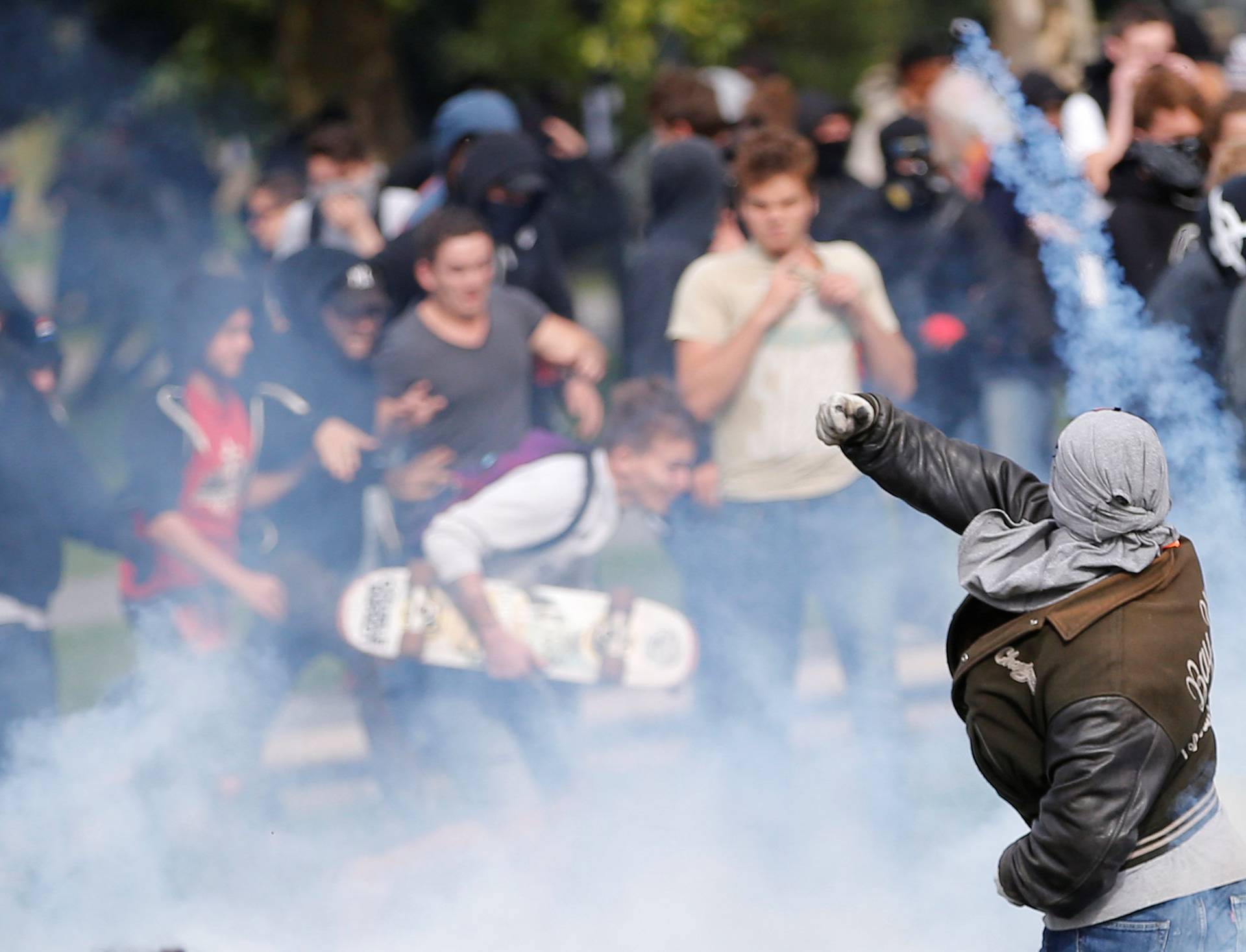 A demonstrator throws back a tear gas during a national strike and protest against the government's labour reforms in Nantes