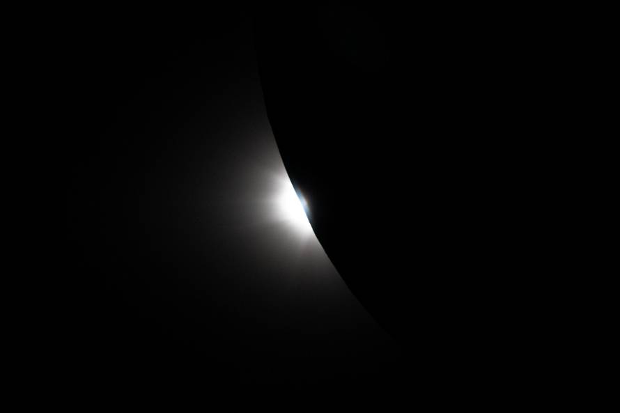 The Sun begins to emerge from behind the Moon as seen from the Orion spacecraft near the end of the Artemis II lunar flyby
