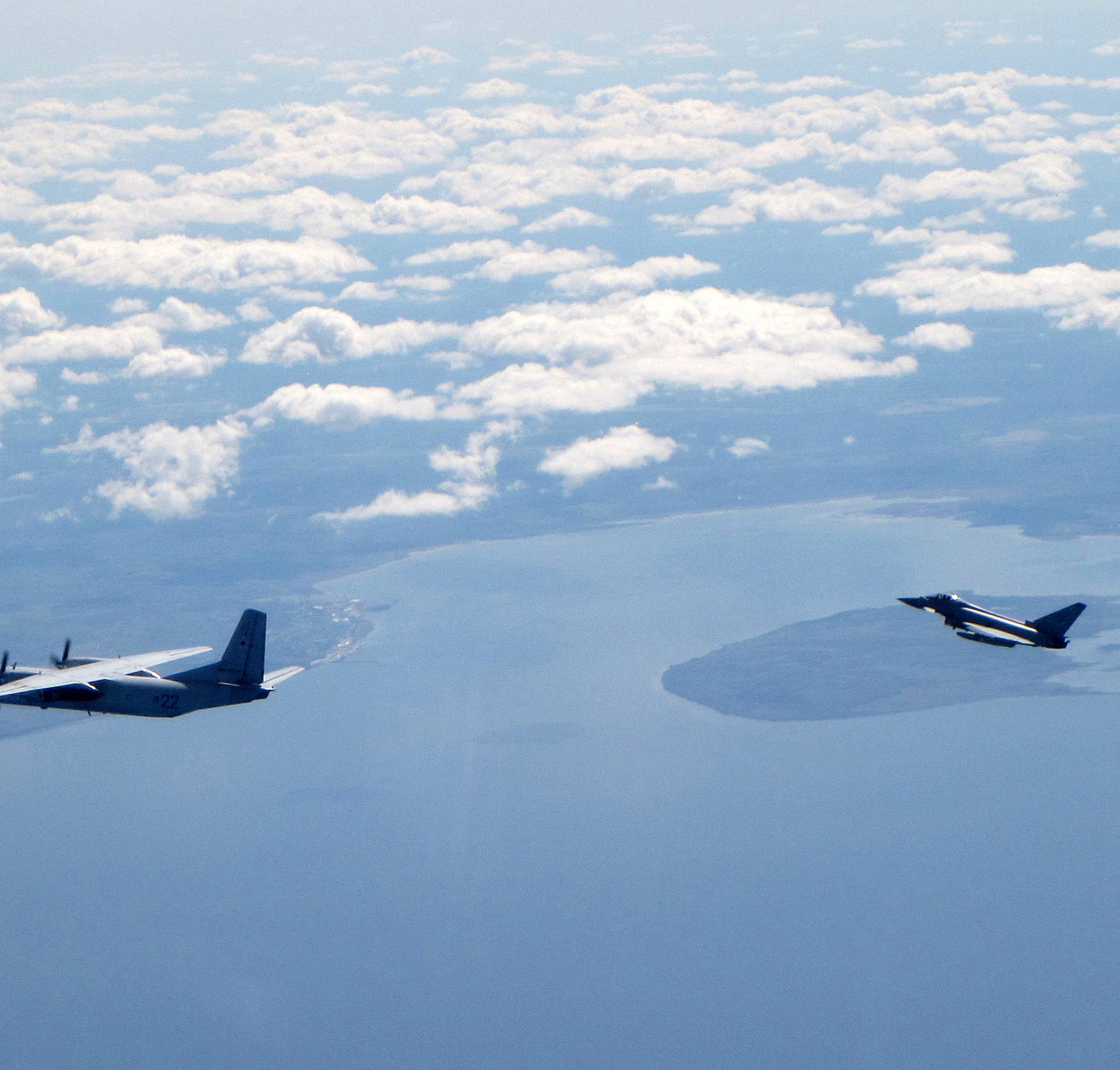A Russian An26 Curl aircraft is shadowed by a RAF Typhoon (R) in this photograph handed out by the Royal Air force