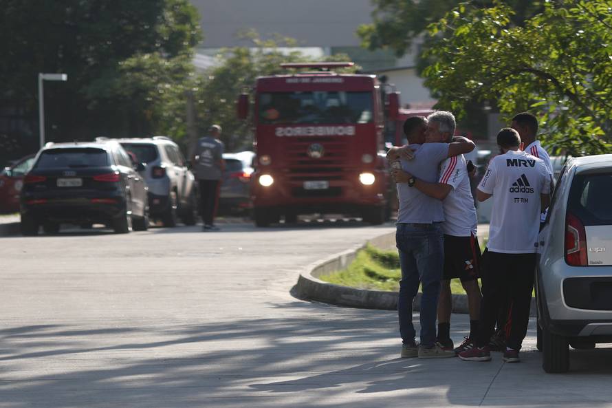 People wait for information in front of the training center of Rio's soccer club Flamengo, after a deadly fire in Rio de Janeiro