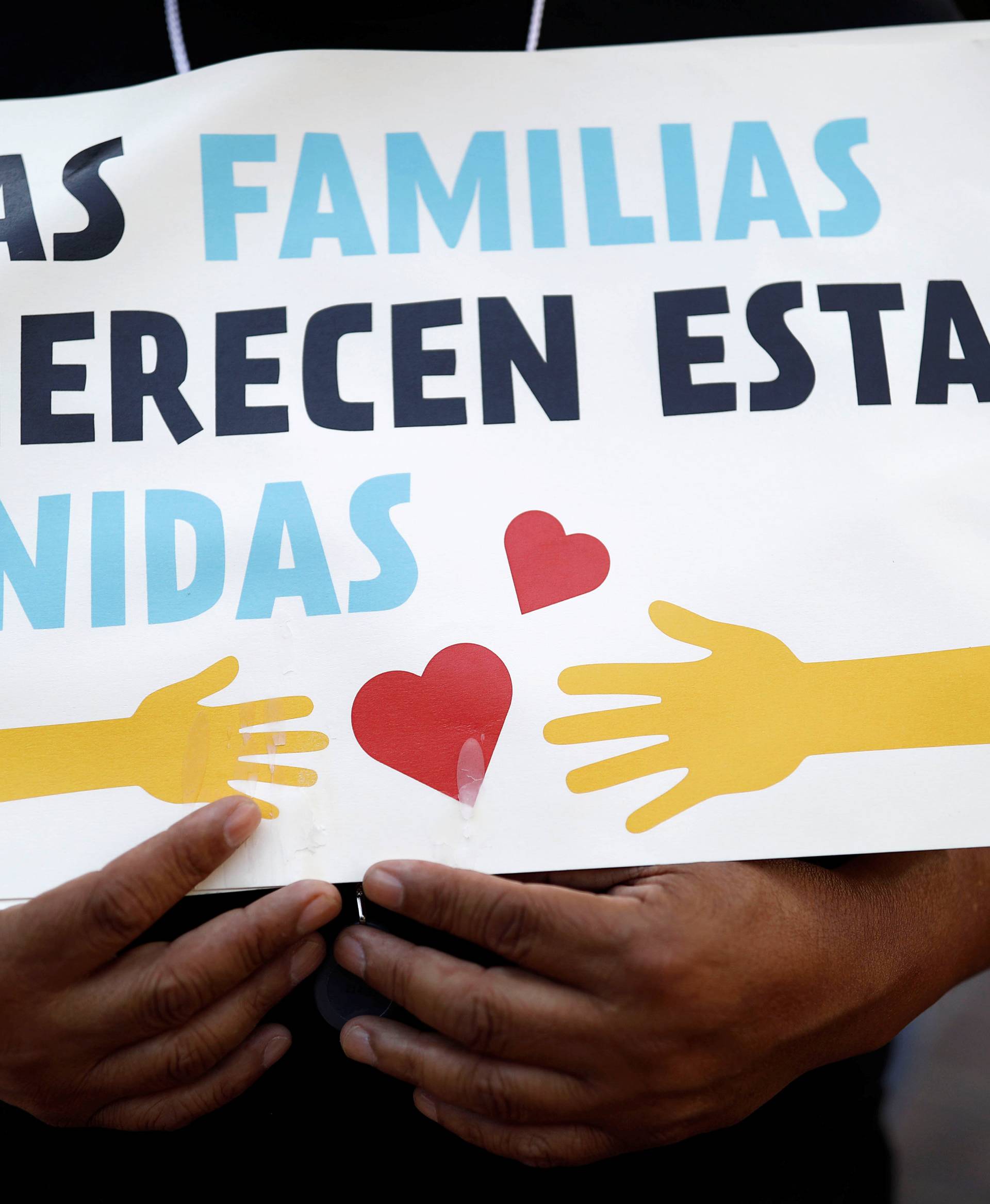 A demonstrator holds a sign during a protest against U.S. President Donald Trump's executive order to detain children crossing the southern U.S. border and separating families outside of City Hall in Los Angeles