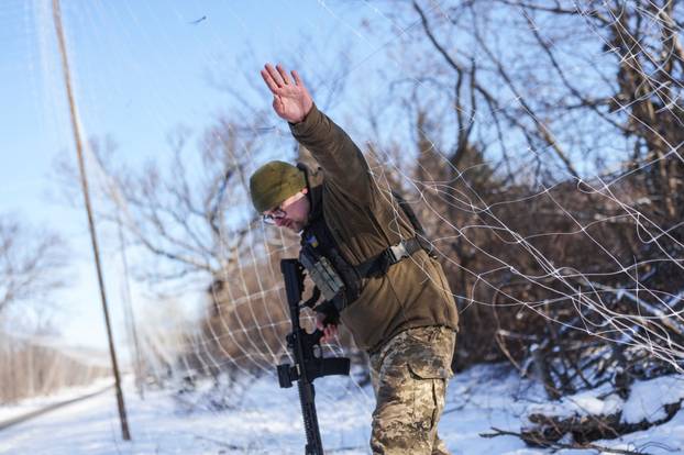 Ukrainian serviceman walks under an anti-drone net near a front line in Donetsk region