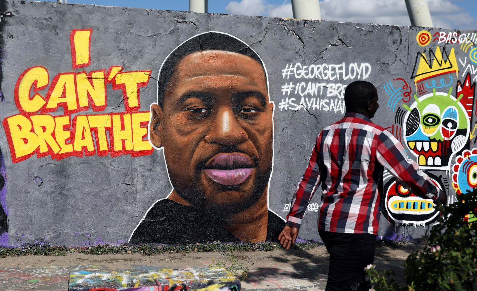 A man walks past a mural depicting African-American man?George?Floyd killed while in police custody in Minneapolis, U.S., at Mauerpark in Berlin