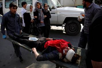 People carry injured woman to hospital after blast in Kabul