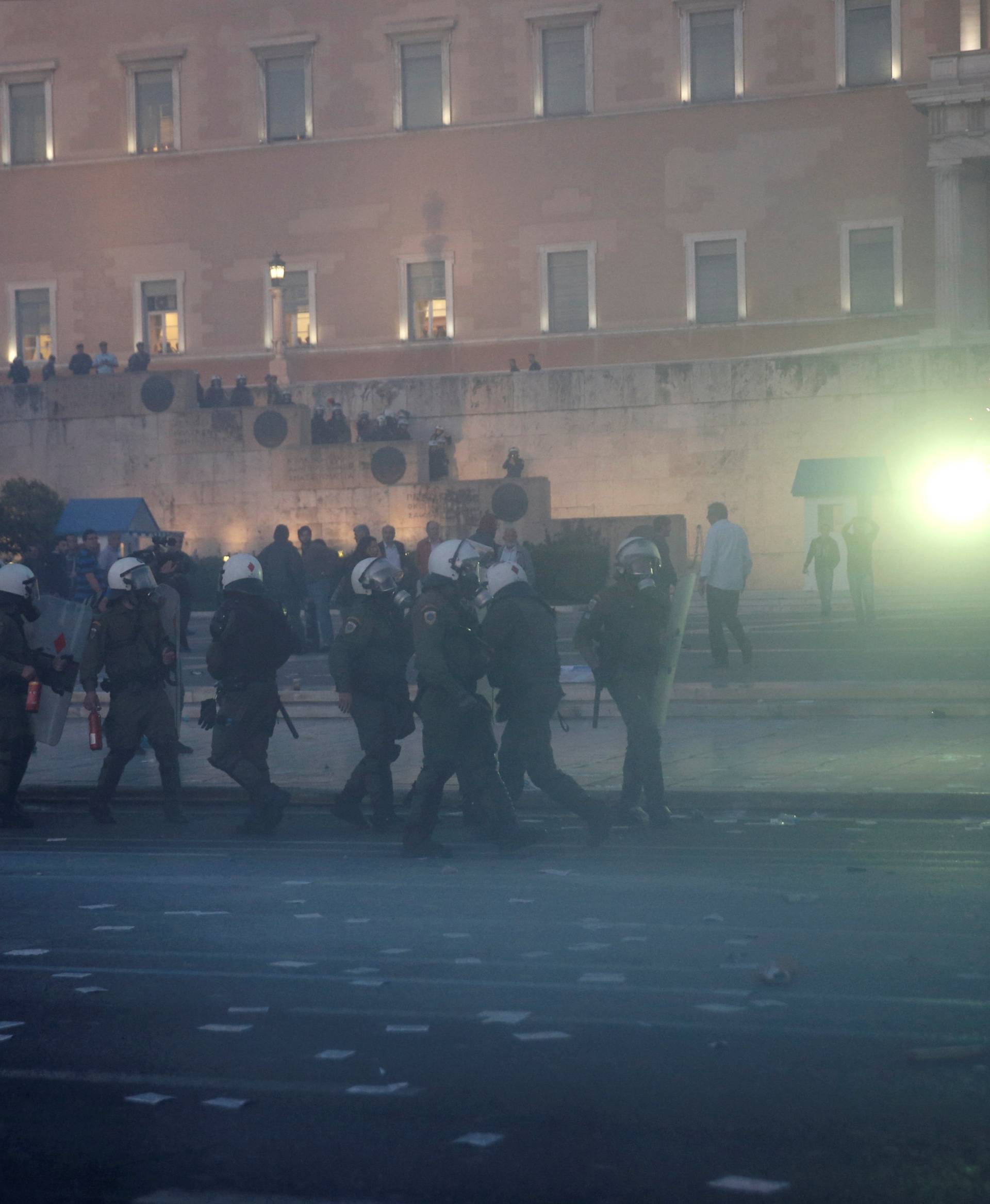 A flare is launched towards Greek riot police officers during minor clashes following a protest outside parliament in central Athens