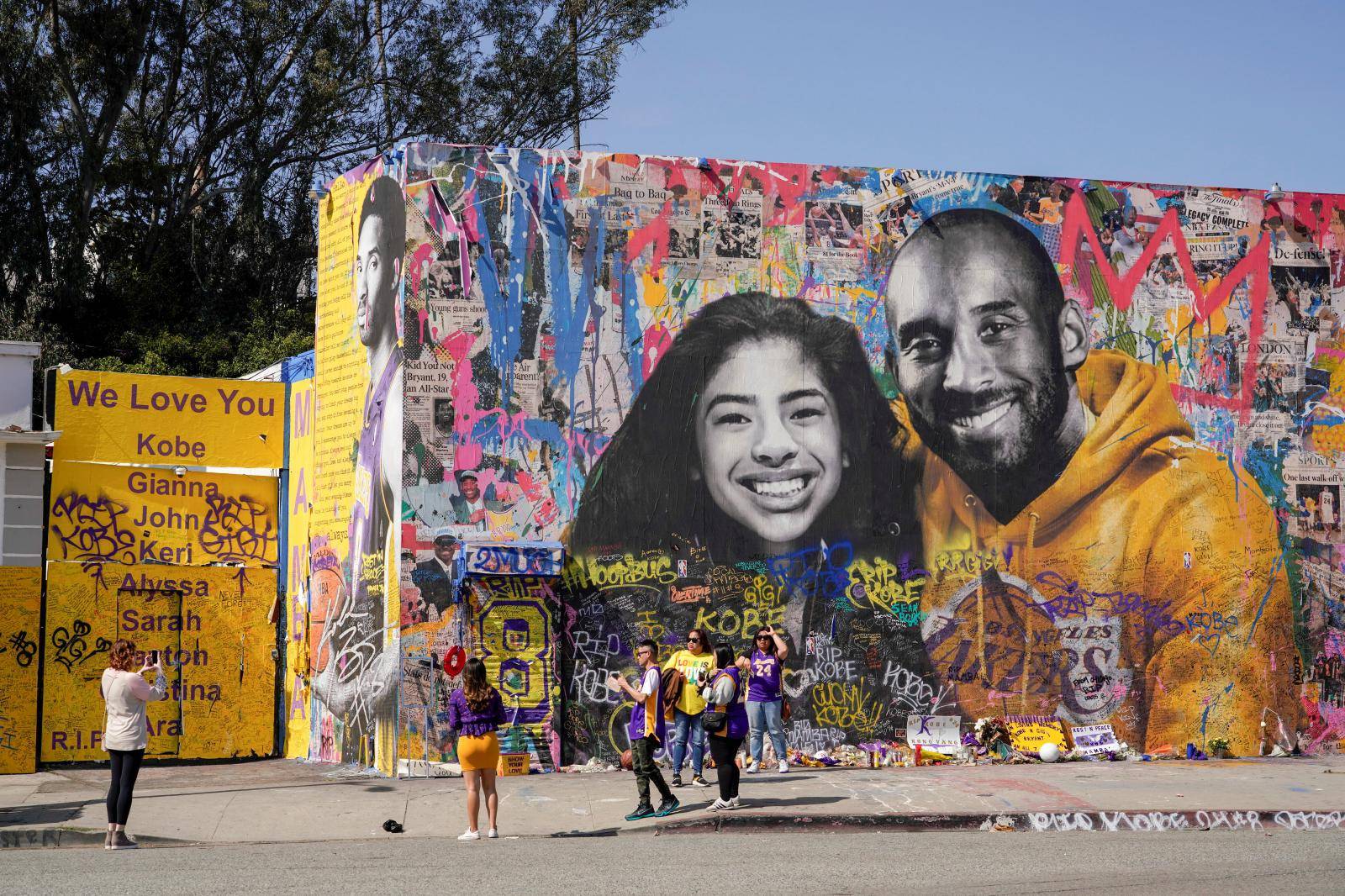 Fans gather around a mural of late NBA great Kobe Bryant and his daughter Gianna Bryant during a public memorial for them and seven others killed in a helicopter crash, at the Staples Center in Los Angeles