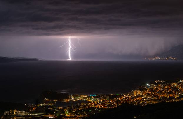 Pogled na Makarsku i munje u bračkom kanalu prema Splitu
