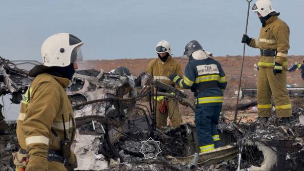 Emergency specialists work at the crash site of a passenger plane near Aktau