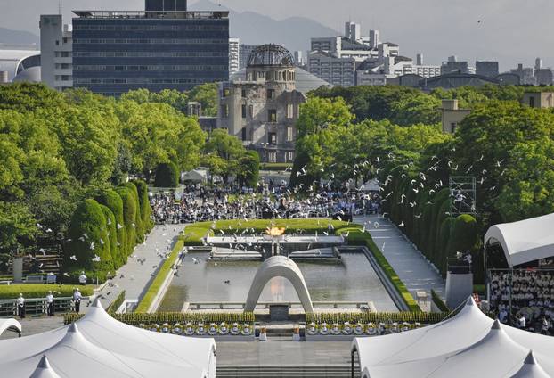 Doves fly over the Peace Memorial Park with a view of the gutted Atomic Bomb Dome at a ceremony in Hiroshima