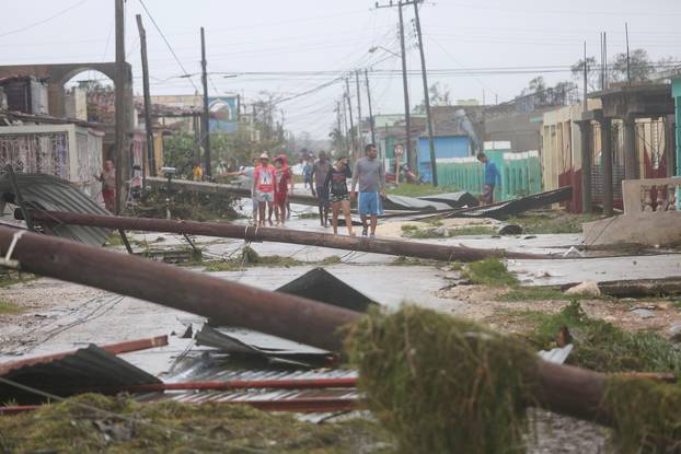 People walk on a damaged street after the passage of Hurricane Irma in Caibarien, Cuba