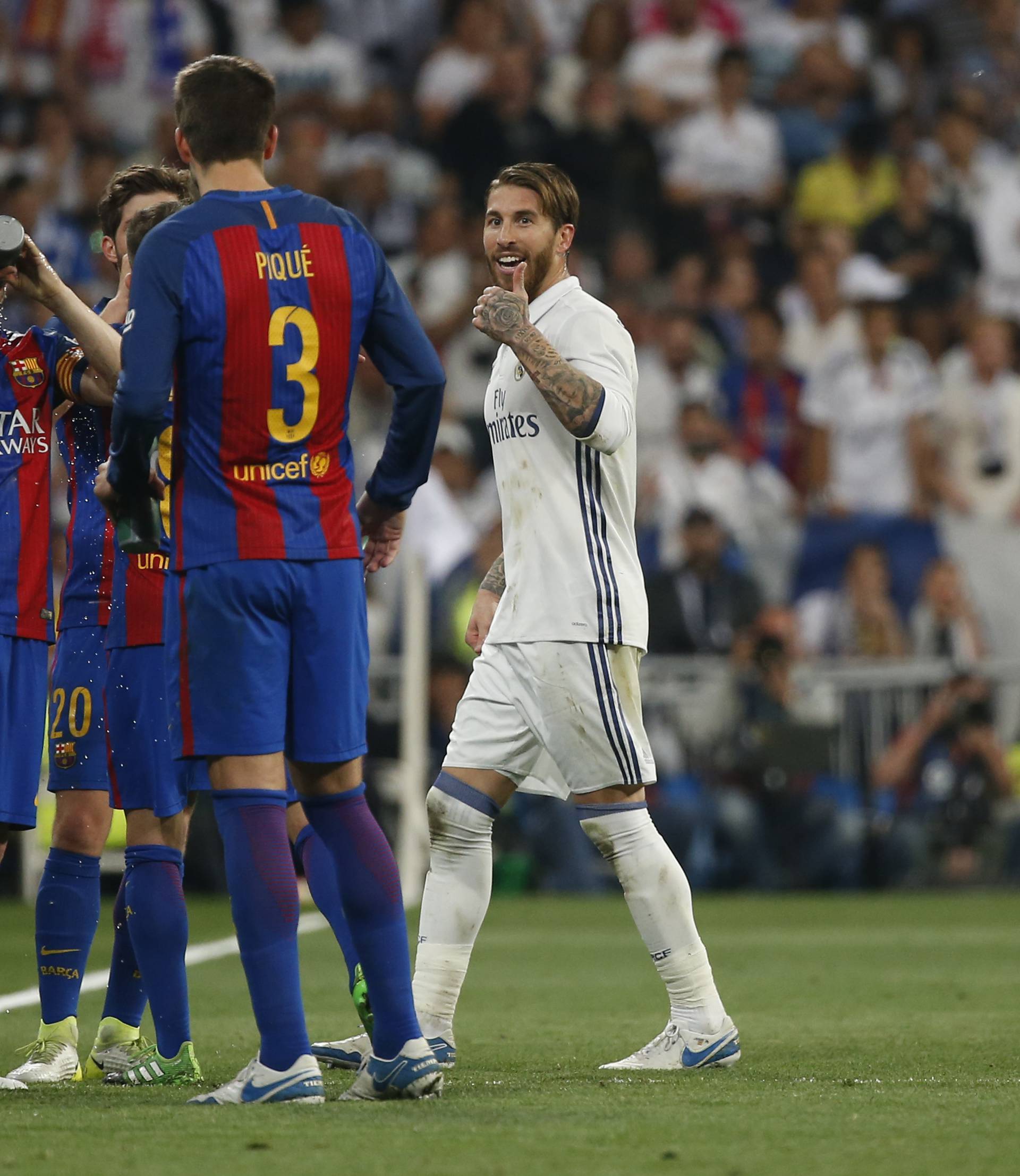 Real Madrid's Sergio Ramos gestures to Barcelona's Gerard Pique after being sent off