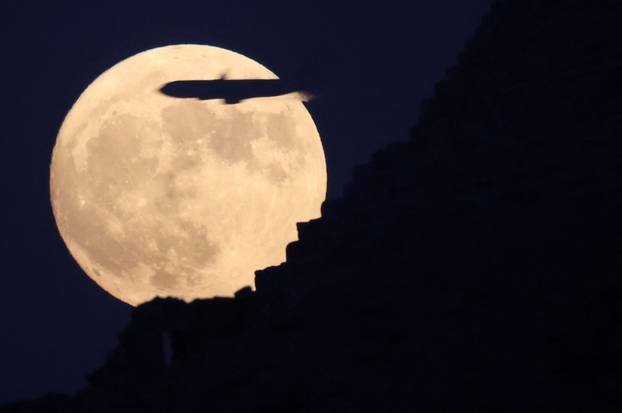 Full moon rises behind the Pyramids of Giza in Egypt