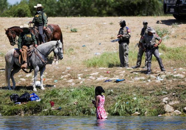 Migrants collecting food try to evade law enforcement at the U.S.-Mexico border